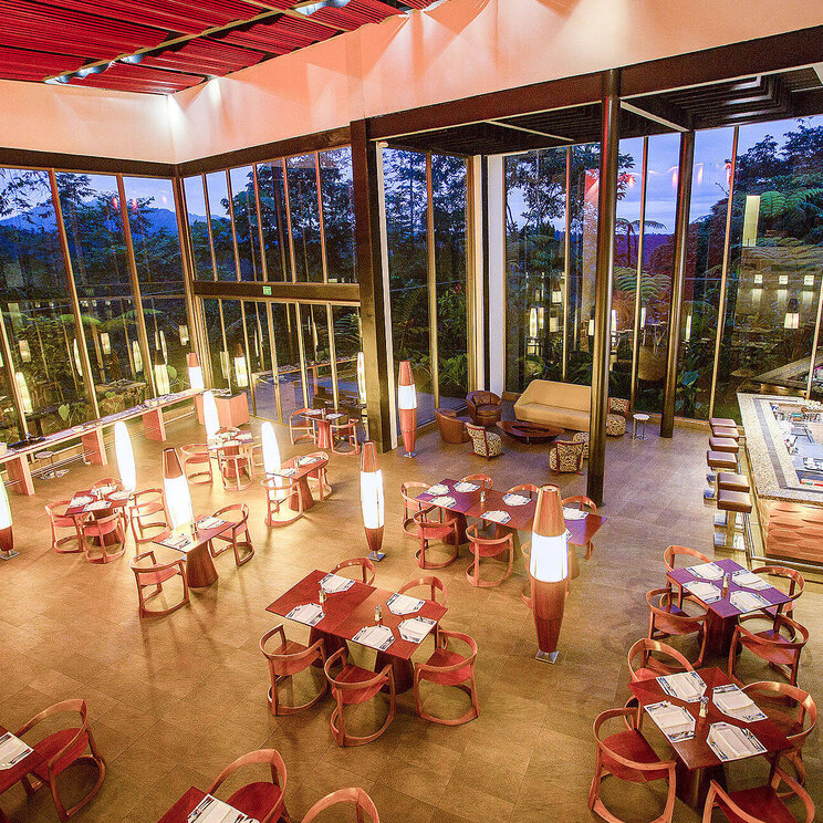 Panoramarestaurant der Mashpi Lodge in Ecuador mit bodentiefen Fenstern, stilvollem Design und Ausblick auf den umliegenden Nebelwald.