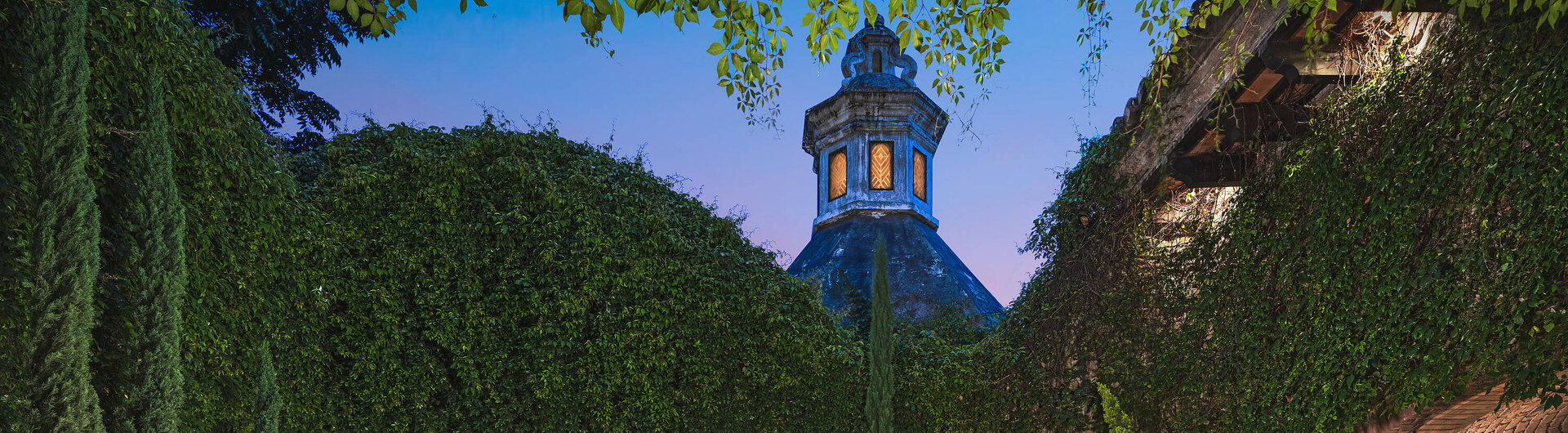 Begrünter Innenhof mit Brunnen und Blick auf den Eingang des El Convento Boutique Hotels in Antigua, Guatemala – stilvolle Kolonialarchitektur mit romantischem Flair in zentraler Lage.