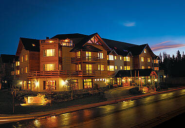 Hotel Kosten Aike mit leuchtenden Fenstern unter Abendhimmel