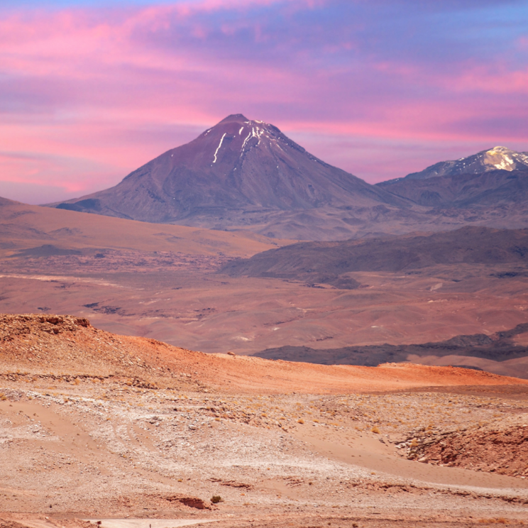 Blick auf den Vulkan Licancabur in der Atacama Wüste mit weiten Hochlandebenen und farbigem Himmel in den frühen Abendstunden.