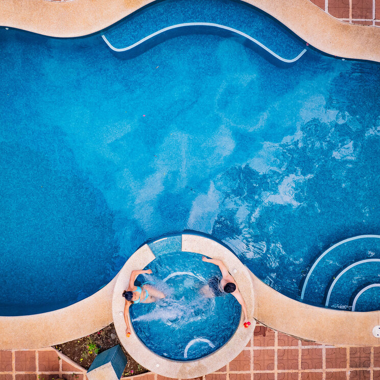Draufsicht auf den Pool und Whirlpool des Hotel Villa Florencia in Costa Rica mit organischer Form und umliegender Terrasse.