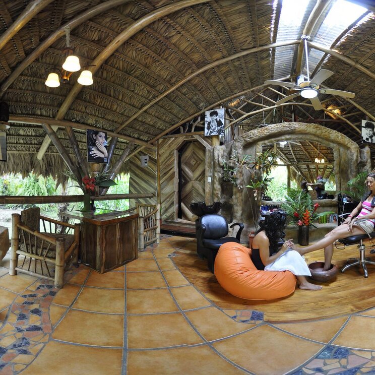 Kosmetiksalon unter einem grossen Reetdach mit Fliesenboden, waehrend eine Frau eine Pedikuere erhaelt, Costa Rica.