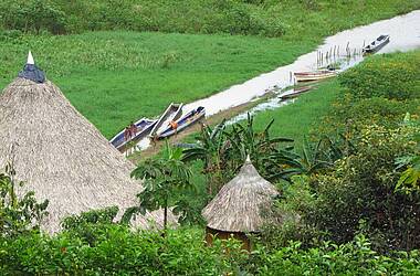 Blick über die Dächer des Embera Dorfes auf den Fluss mit Booten