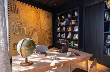 Schreibtisch mit Globus vor einer grossen Landkarte in der Hotelbibliothek in Chile.