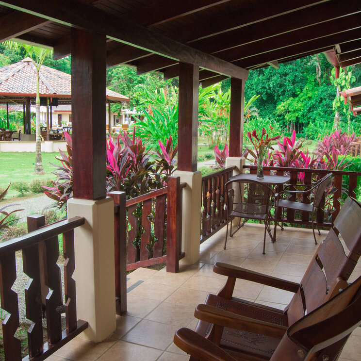 Private Terrasse der Villa im La Foresta Nature Resort in Manuel Antonio, Costa Rica, mit Schaukelstühlen und Blick auf den tropischen Garten.