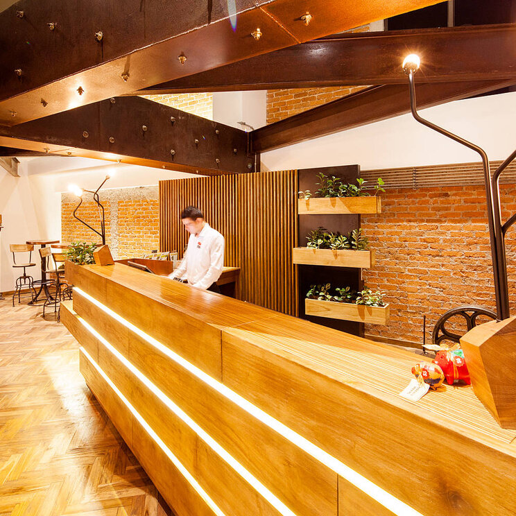 Rezeption im Hotel Presidente in San José, Costa Rica, mit modernem Design und stilvollen Holzregalen.