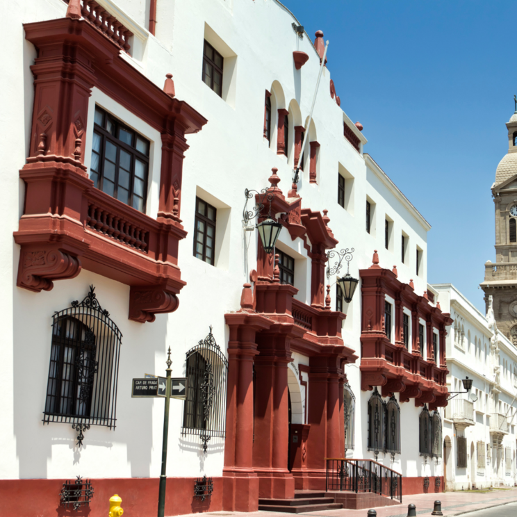 Historische Kolonialarchitektur im Stadtzentrum von La Serena mit weiß roten Fassaden und Kirchturm an der Küstenstraße Nordchiles.