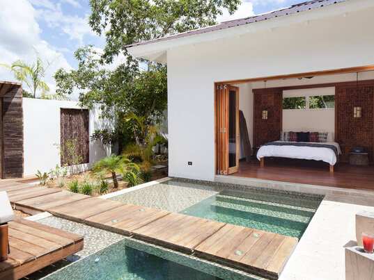 Privater Poolbereich mit Holzstegen und direktem Zugang zum Schlafzimmer im Ka'ana Resort in San Ignacio, Belize.