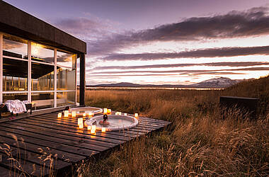 Terrasse mit Whirlpools des Hotel Remota Patagonia am Abend