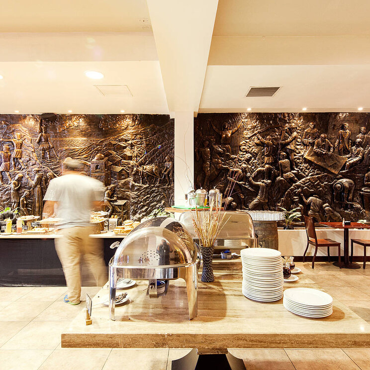 Frühstücksbereich im Hotel Presidente in San José, Costa Rica, mit einer dekorativen Wand und einem Buffet.