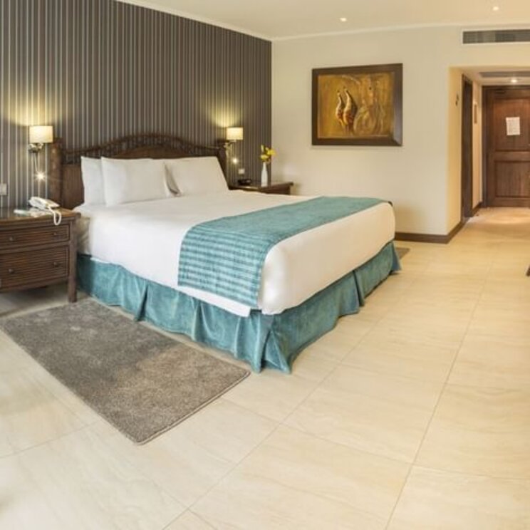 Deluxe Doppelzimmer im Camino Real Hotel Santa Cruz mit hellem Fliesenboden und dunkler Akzentwand.