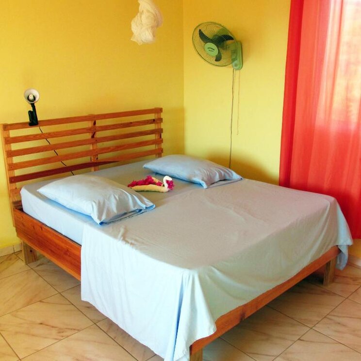 Einfach eingerichtetes Zimmer im Hotel Corales in Punta Rucia in der Dominikanischen Republik mit Doppelbett und Ventilator.