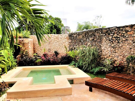 Kleiner Aussenpool umgeben von einer Steinmauer und tropischen Pflanzen im Hotel Casa de Tia Micha, Valladolid.