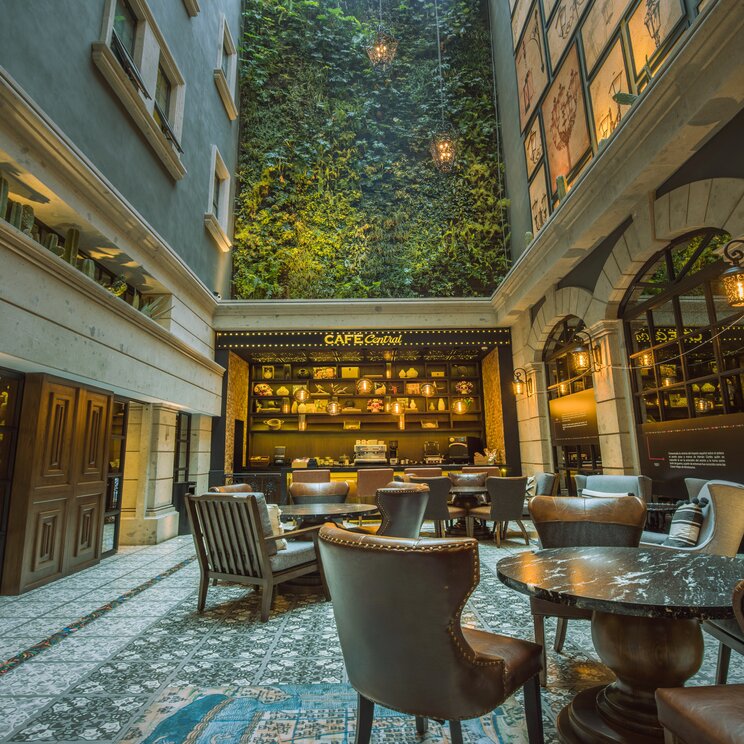 Innenhof mit Café und begrünter Wand im Hotel Zócalo Central im historischen Zentrum von Mexiko-Stadt in Mexiko.