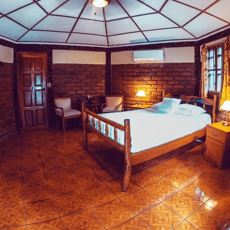 Dachzimmer im Hotel Villa Paraíso auf der Insel Ometepe, Nicaragua, mit rustikaler Holzverkleidung, sichtbaren Deckenbalken und gemütlicher Kuppeldecke.