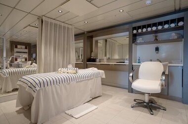 Der Wellnessbereich an Bord der Ocean Albatros mit Massageliege und hellen Behandlungsräumen zur Entspannung