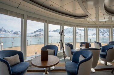 Blick durch die großen Fenster der Lounge auf dem Antarktis Kreuzfahrtschiff Ocean Albatros