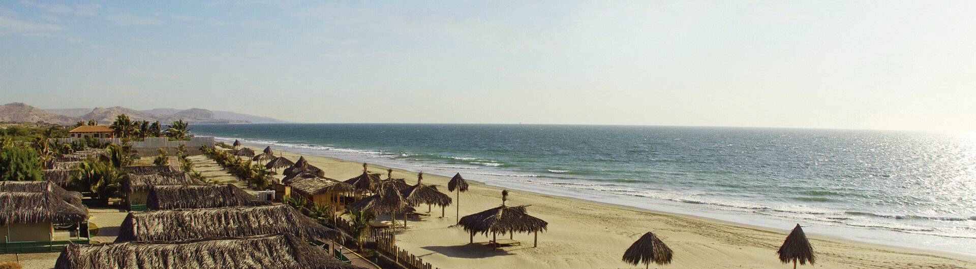 Aranwa: Strandbungalows mit Strohdächern an einer weitläufigen, menschenleeren Pazifikküste.