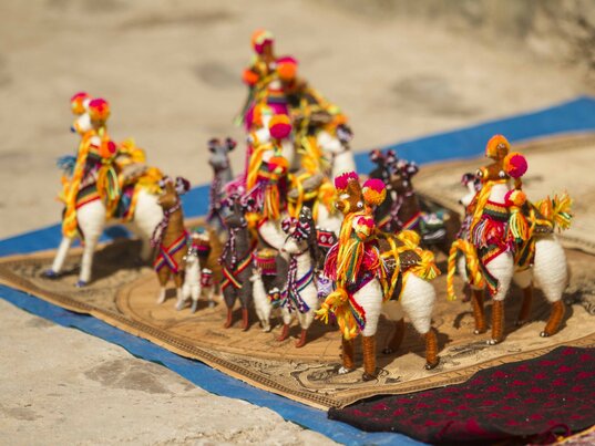 Bunte, handgefertigte Lama-Figuren aus Wolle auf einem Marktstand in Tarabuco, Bolivien.