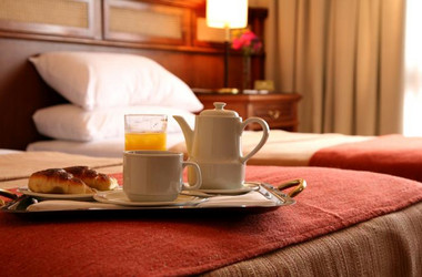 Frühstückstablett auf einem Bett im Hotel Ayres de Salta