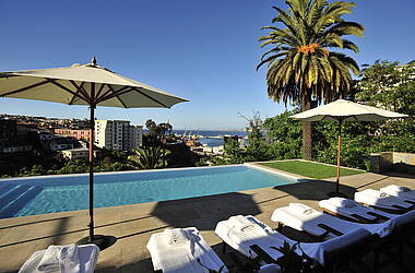 Pool des Hotels Casa Higueras mit Liegestühlen und Sonnenschirmen