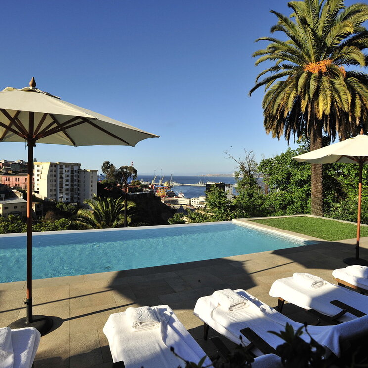 Pool des Hotels Casa Higueras mit Liegestühlen und Sonnenschirmen