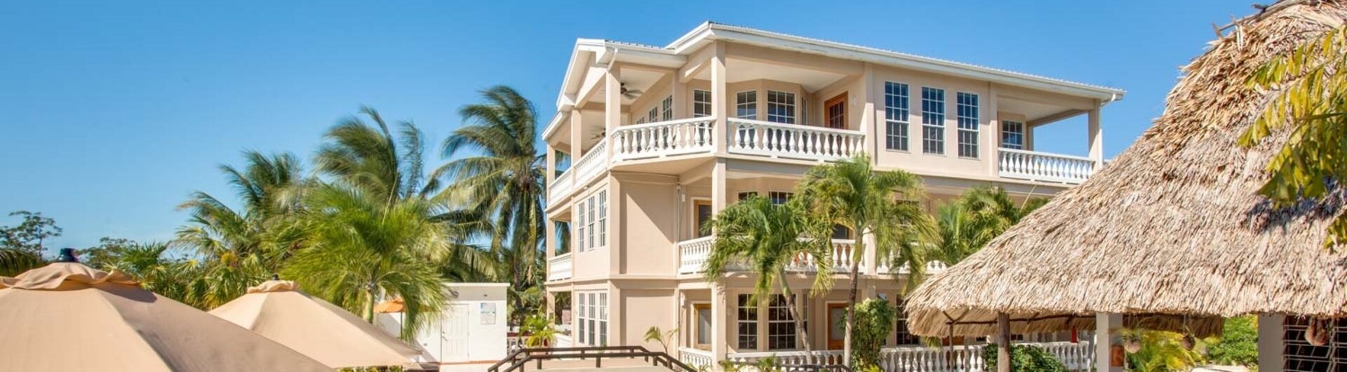Außenpool und Sonnendeck eines Resorts mit Strohdach-Pavillon auf Caye Caulker in Belize