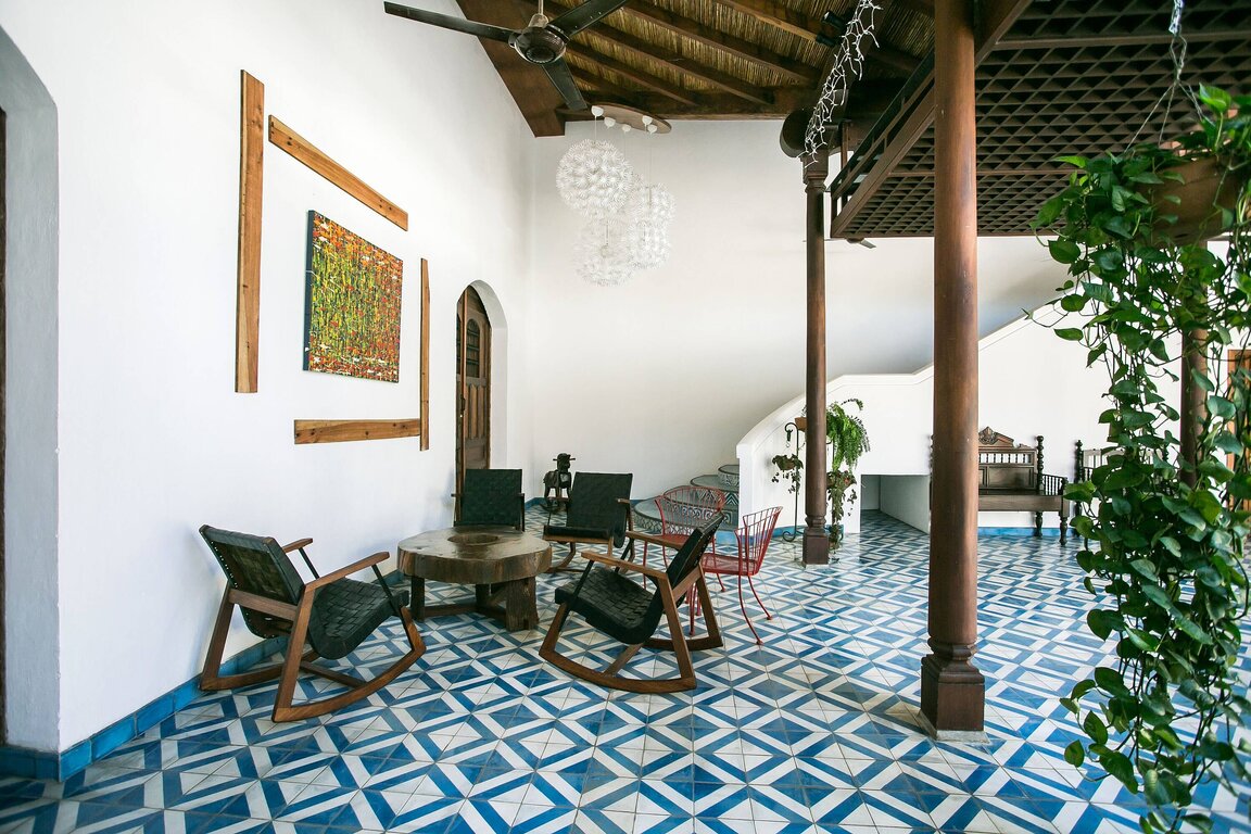 Sitzbereich im Hotel Real Continental in Managua, Nicaragua, mit Schaukelstühlen und modernem Design auf blau gemustertem Fliesenboden.