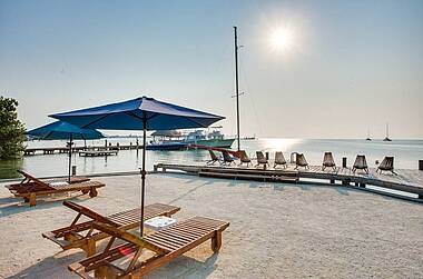 Strand am Iguana Reef Inn mit Liegestühlen und Steg