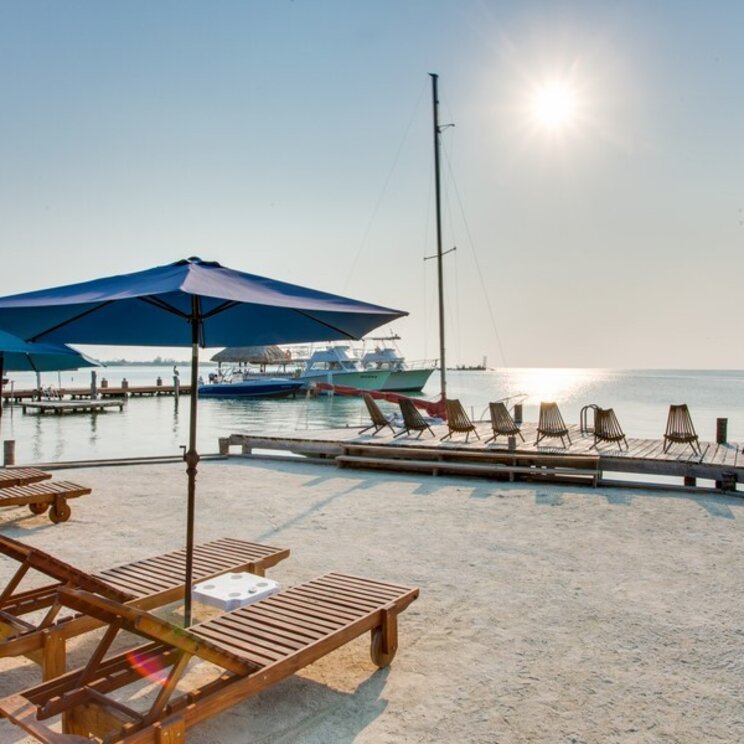 Strand am Iguana Reef Inn mit Liegestühlen und Steg