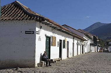 Alter Mann sitzt vor einem kleinen Häusschen in Villa de Leyva