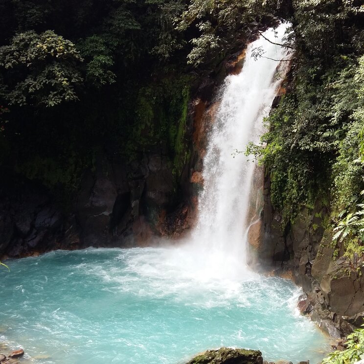 Der maechtige Wasserfall des Rio Celeste stuerzt in ein intensiv hellblaues Becken im Tenorio Nationalpark.