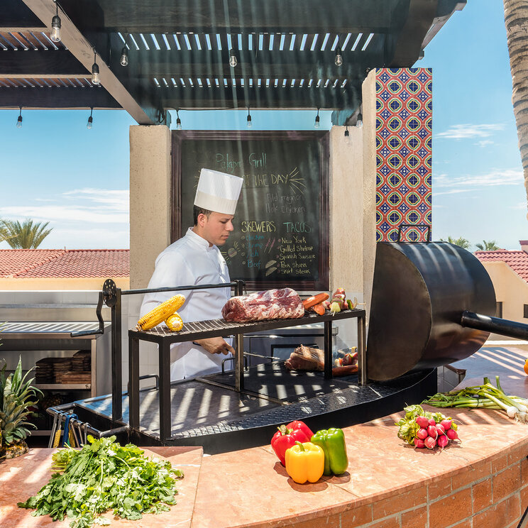 Koch bereitet frische Speisen an einer Palapa-Grillstation im Solmar Resort in Cabo San Lucas in Mexiko zu.