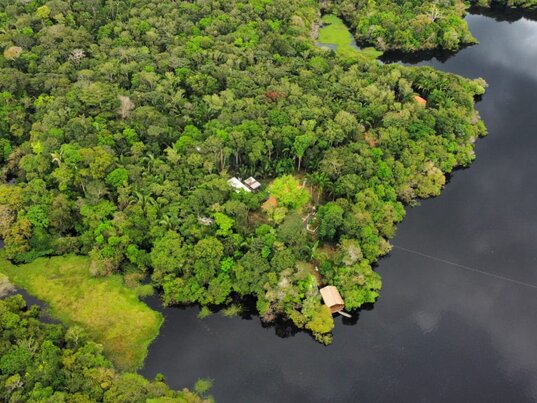 Luftaufnahme der Amazon Premium Lodge im Amazonas, Brasilien, mit Blick auf das grüne Gelände und den umgebenden Fluss.