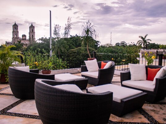 Dachterrasse mit Loungemöbeln und Blick auf die Kathedrale von Valladolid in Mexiko.