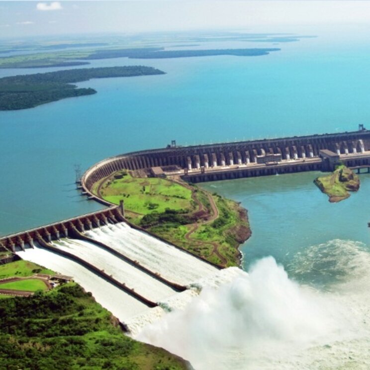 Der Itaipú-Staudamm an der Grenze zwischen Brasilien und Paraguay, mit beeindruckendem Wasserfluss und umgebender Landschaft.
